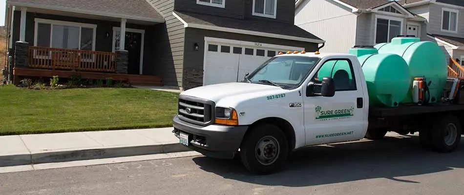 Sure Green Lawn & Tree Service work truck preparing lawn fertilization treatment in Spokane, WA.